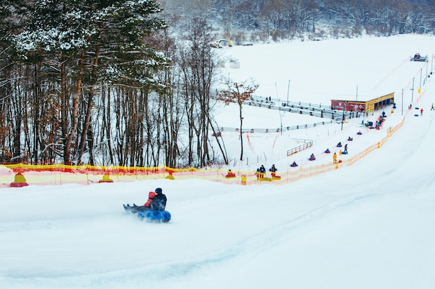 People having fun snow tubing down by winter hill