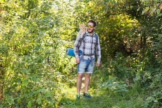 人、ハイキング、観光、自然の概念-森の中で彼の猫と男