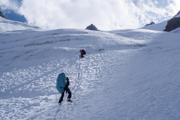 People hiking on snowcapped mountain during winter