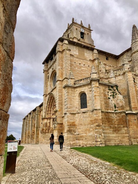 People at historic building against sky