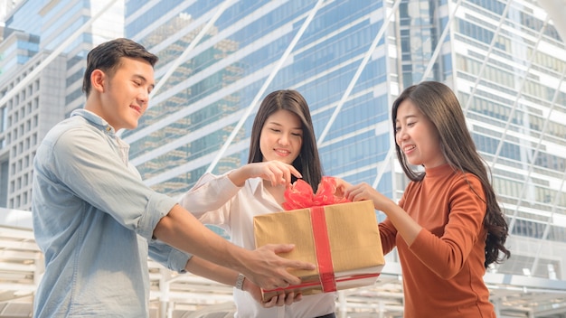 people hold box of gift with red ribbon