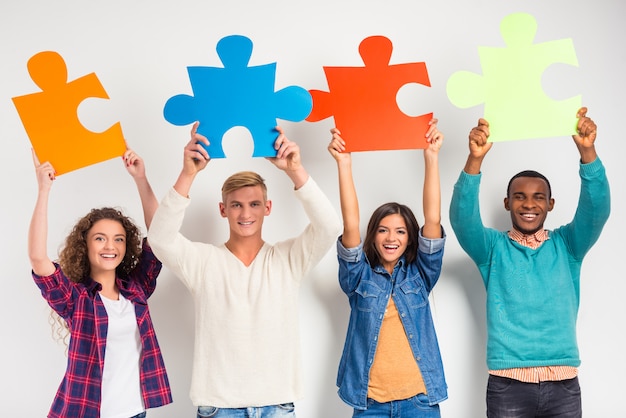 People holding big puzzles pieces