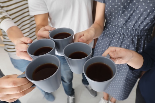 People holding cups of coffee together. Unity concept