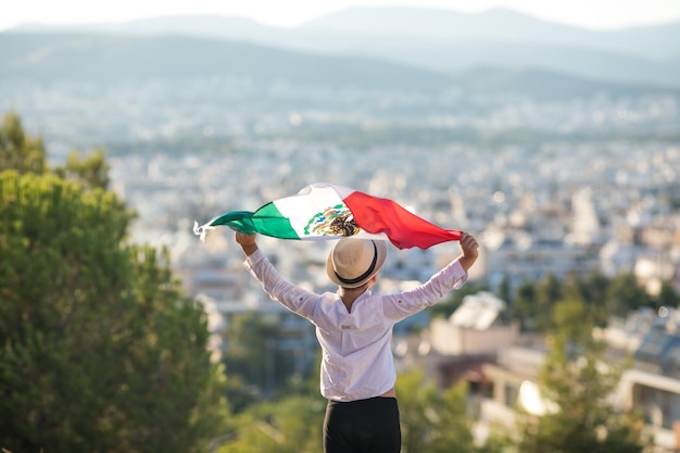 Persone in possesso di bandiera del messico 16 settembre giorno dell'indipendenza del messico