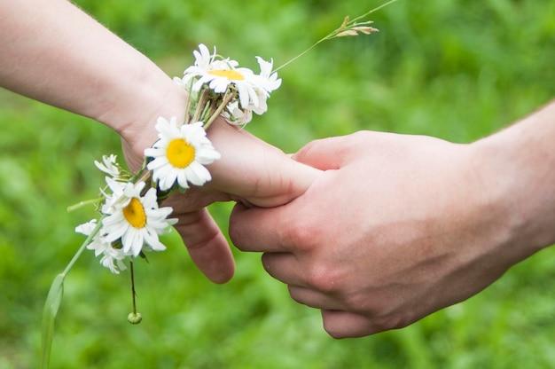 people holding hands on a daisy bracelet