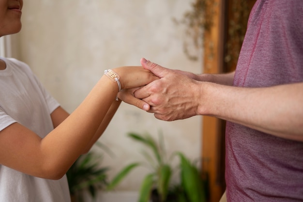 Foto persone che si tengono per mano e pregano vista laterale