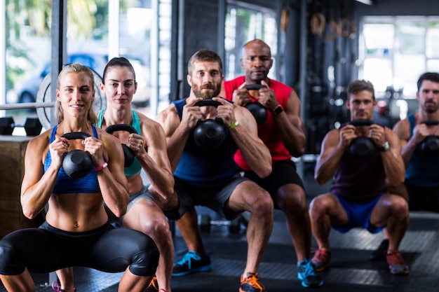 체육관에서 kettlebells을 잡고 사람들