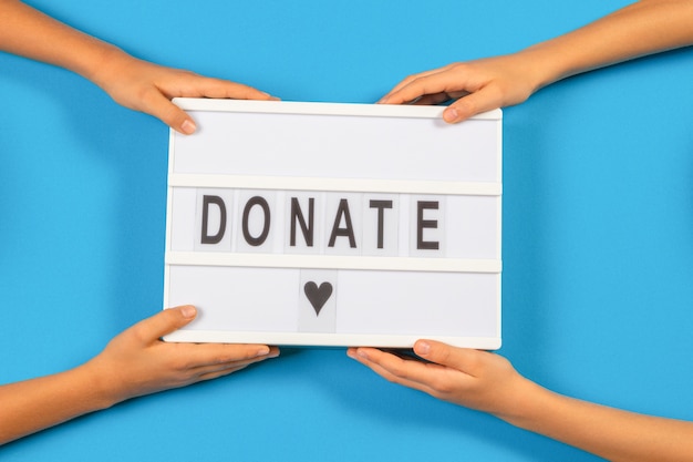 Photo people holding light box with the word donate