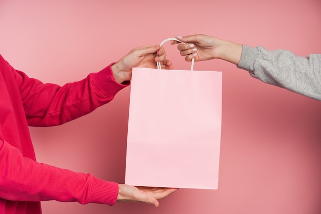 People holding pink paper bag  .