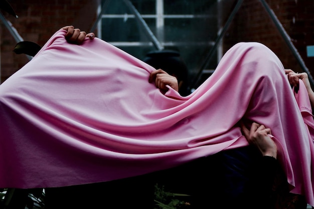 People holding pink textile while standing outdoors