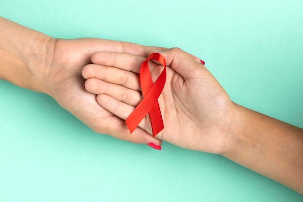 Persone in possesso di un simbolo rosso della giornata mondiale contro l'AIDS