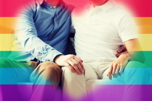 写真 人、同性愛、同性結婚、魅力、愛のコンセプト – 虹色の旗の背景に抱き合う幸せな男性同性愛者のカップルの接写