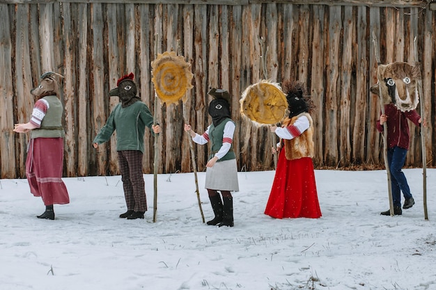 写真 動物の頭を持つ民族衣装を着た人々は異教の休日の到来を祝いますmaslenitsa古代のページ