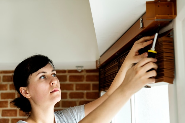 People installing window curtain