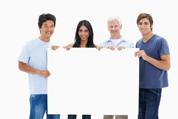 People in jeans holding a big sign 