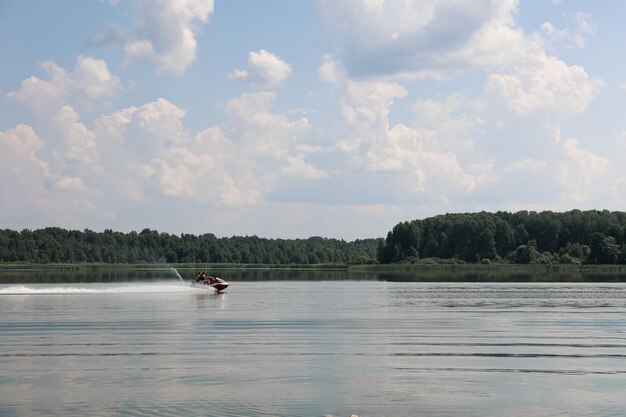 Люди катаются на водном мотоцикле по озеру жарким летом