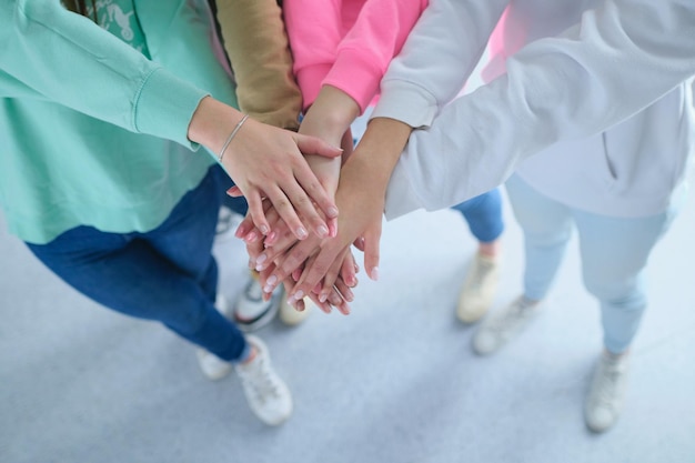 People joining hands young women standing together