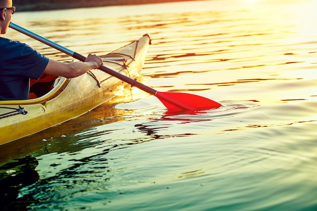 Persone in kayak durante il tramonto sullo sfondo. divertiti nel tuo tempo libero.
