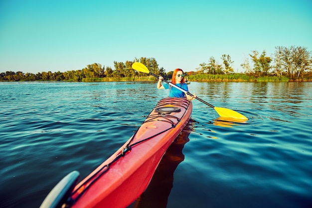 People kayak during sunset in the background. Have fun in your free time.