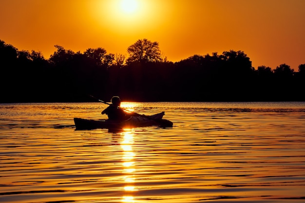 People kayak during sunset in the background. Have fun in your free time.