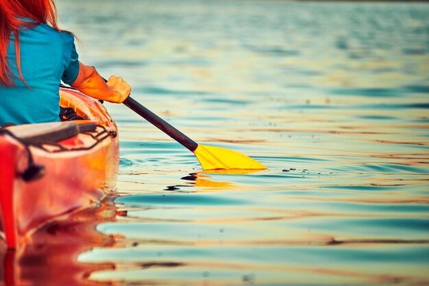 People kayak during sunset in the background. Have fun in your free time.