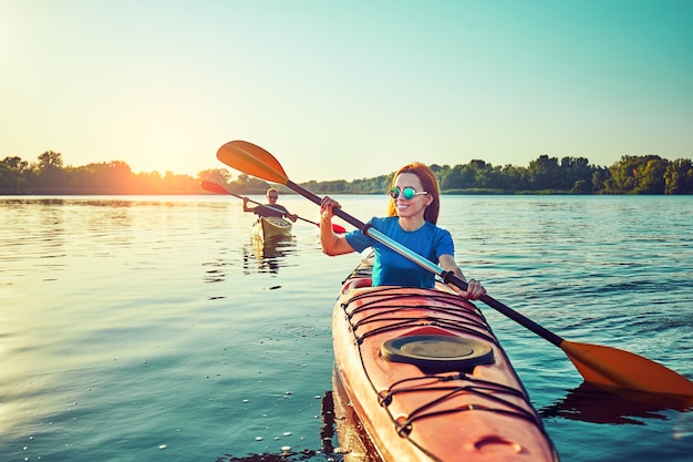 People kayak during sunset in the background. Have fun in your free time.