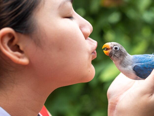 人々はかわいい愛の鳥にキスをします