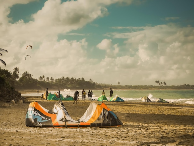 Photo people kiteboarding at beach against sky