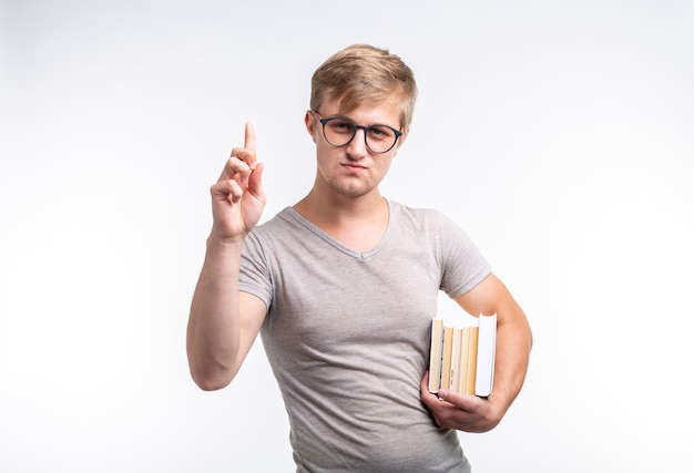 사람, 지식 및 교육 개념-그의 손에 책을 들고 회색 티셔츠를 입은 학생 남자의 초상화.