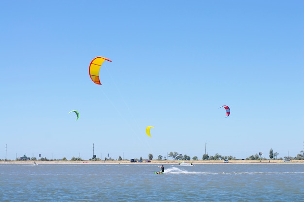 People on the lake are kitesurfing