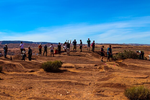 People on landscape against blue sky