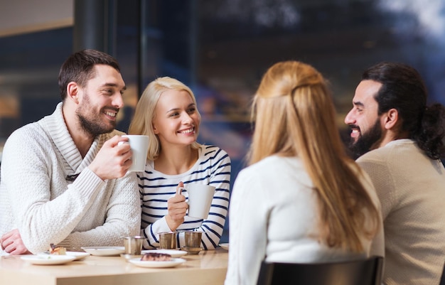 사람, 여가, 커뮤니케이션, 먹고 마시는 개념 - 행복한 친구들이 카페에서 만나 차나 커피를 마시는 것