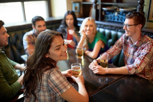 사람, 레저, 우정, 커뮤니케이션 개념 - 행복한 친구들이 맥주를 마시고 술집이나 술집에서 이야기를 나눕니다.