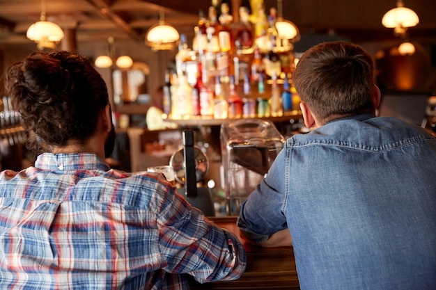 people, leisure and friendship concept - close up of male friends at bar counter in pub