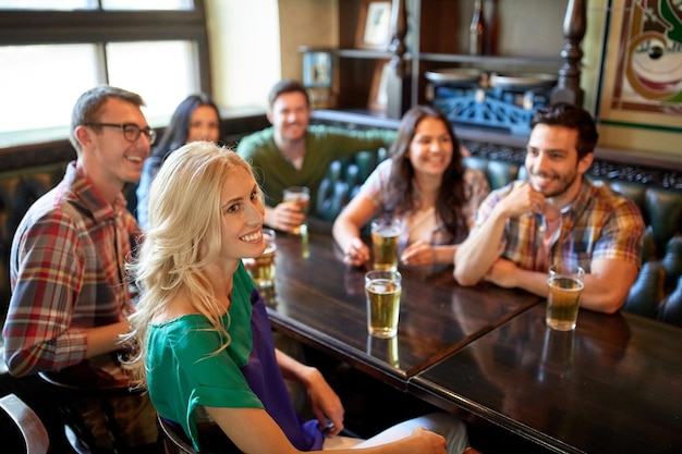 Foto concetto di persone, tempo libero, amicizia e intrattenimento - amici felici che bevono birra e guardano partite sportive o partite di calcio al bar o al pub