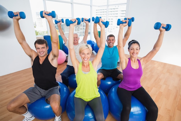 People lifting weights in gym class