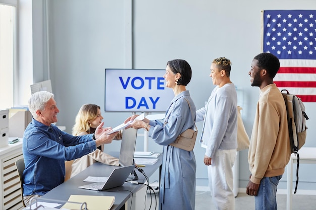 Foto persone in fila alla stazione di voto