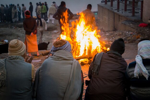 People look at the funeral pyre that night. The ceremony of the cremation of Manikarnika Ghat on the banks of the Ganges river in Varanasi, India.