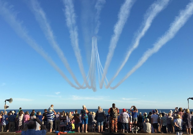 Photo people looking at airshow over sea