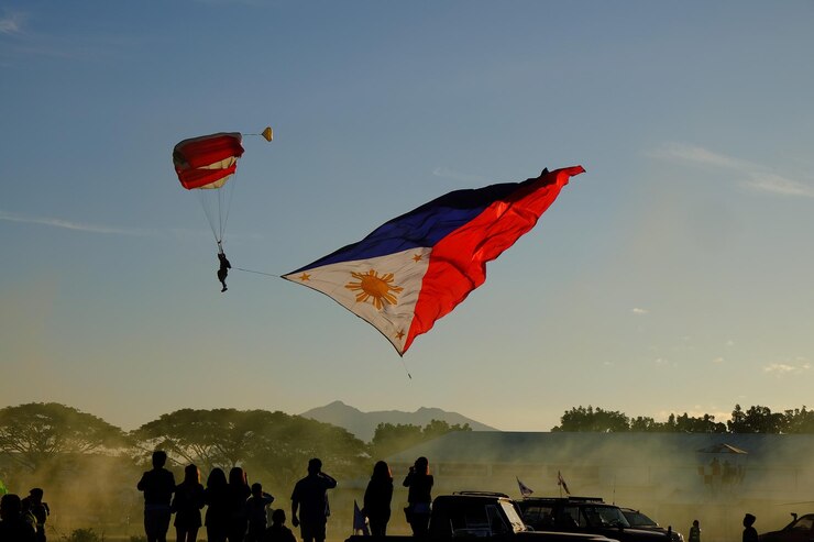 Photo people looking at person paragliding against sky during sunset