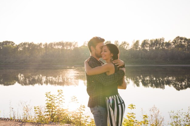 People, love and nature concept - Portrait of young beautiful couple embracing each other while