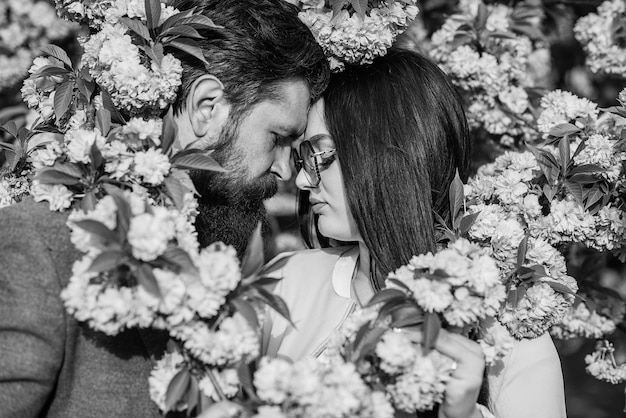 日本の桜とロマンチックな歩道を愛する人々は、新鮮な花のリンゴや桜の庭でキスしますカップルは春の庭で時間を過ごしますハッピーイースターロマンチックなデートのカップルのコンセプト
