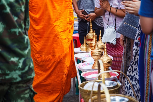 people make merits by giving food offerings to Buddhist monks on daily morning alms 