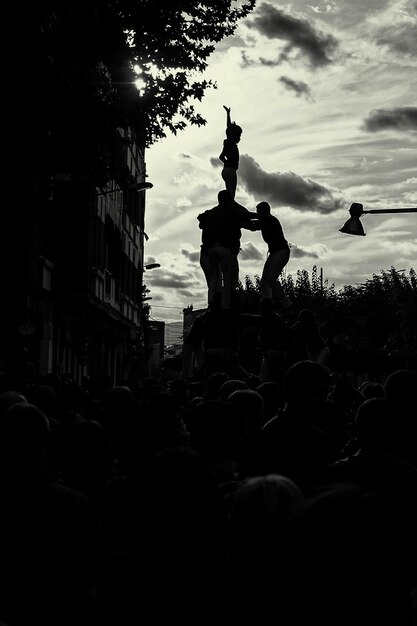 Photo people making human pyramid on street against sky