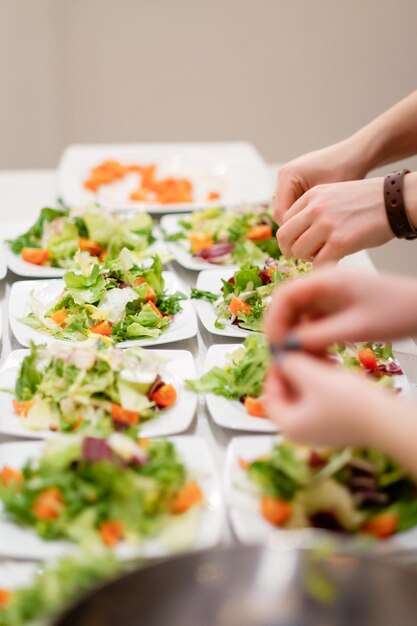 Persone che fanno insalata insieme in attesa di ospiti una coppia aggiunge spezie alle insalate concetto di cucina casalinga cibo sano
