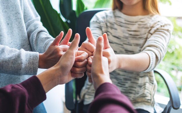 People making thumb up hands sign in circle