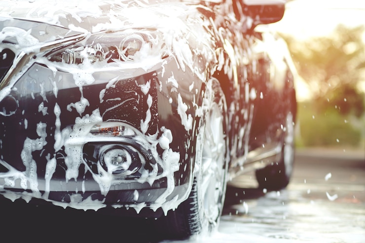 Photo people man holding hand pink sponge for washing car. concept car wash clean.	