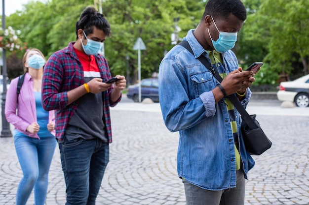 People in masks stand queue keeping social distance