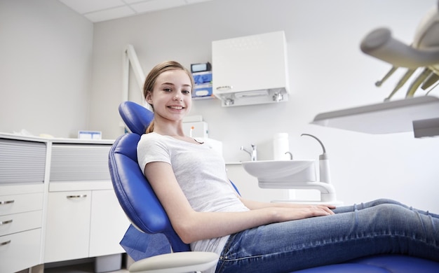 people, medicine, stomatology, dentistry and health care concept - happy patient girl at dental clinic office