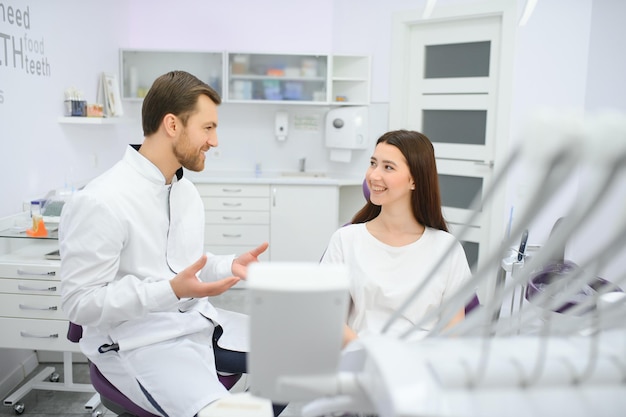 Photo people medicine stomatology and health care concept woman patient talking to male dentist and complain of toothache at dental clinic office